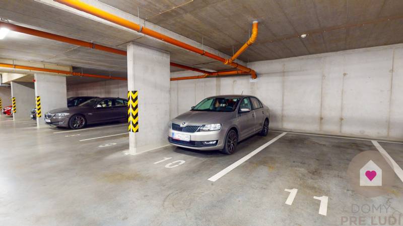 Unterirdischer Parkplatz in Zuzany Chalupovej, Bratislava - Petržalka, mit mehreren geparkten Autos.