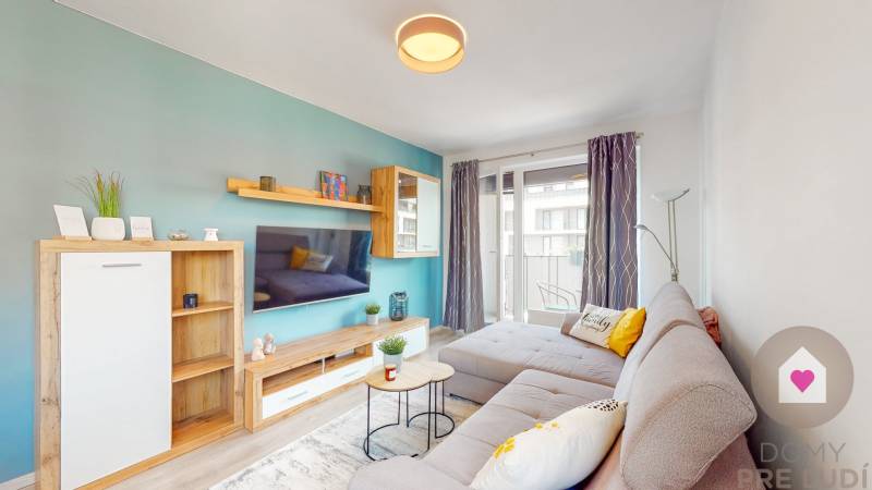 Wohnzimmer in einer 3-Zimmer-Wohnung mit einem bequemen Sofa und einem Balkon, Boden mit Holzdekor.