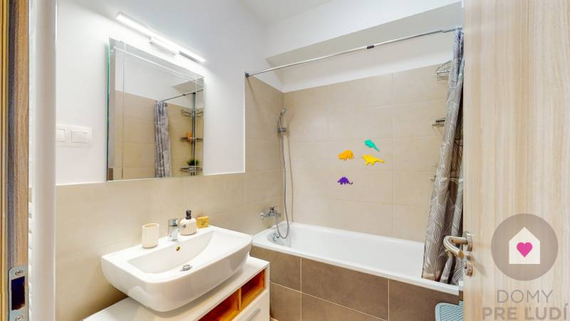Badezimmer in einer 3-Zimmer-Wohnung mit Badewanne, Spiegel und dekorativen Aufklebern.