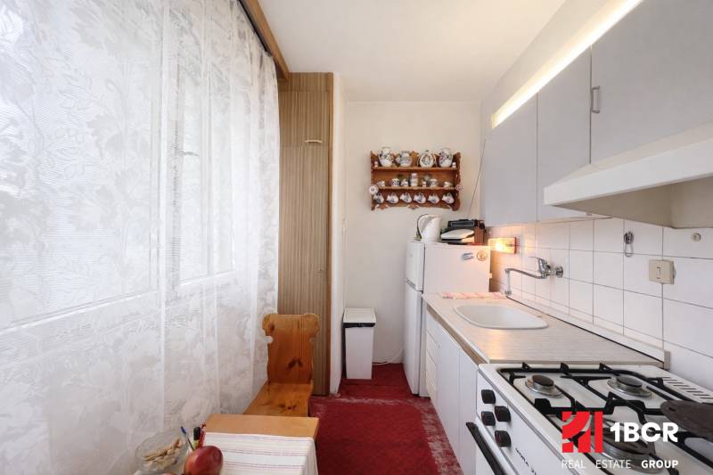 Gemütliche Küche mit Gasherd und rustikaler Dekoration in einer Einzimmerwohnung.