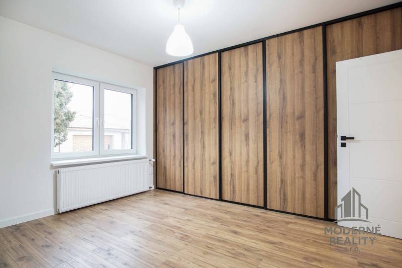 Ein Zimmer mit einem Holzboden und einem großen Einbauschrank in einem Einfamilienhaus.