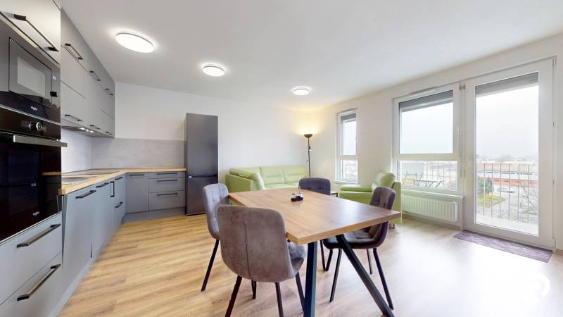 Küche mit Holzboden und Esstisch in einer 3-Zimmer-Wohnung.