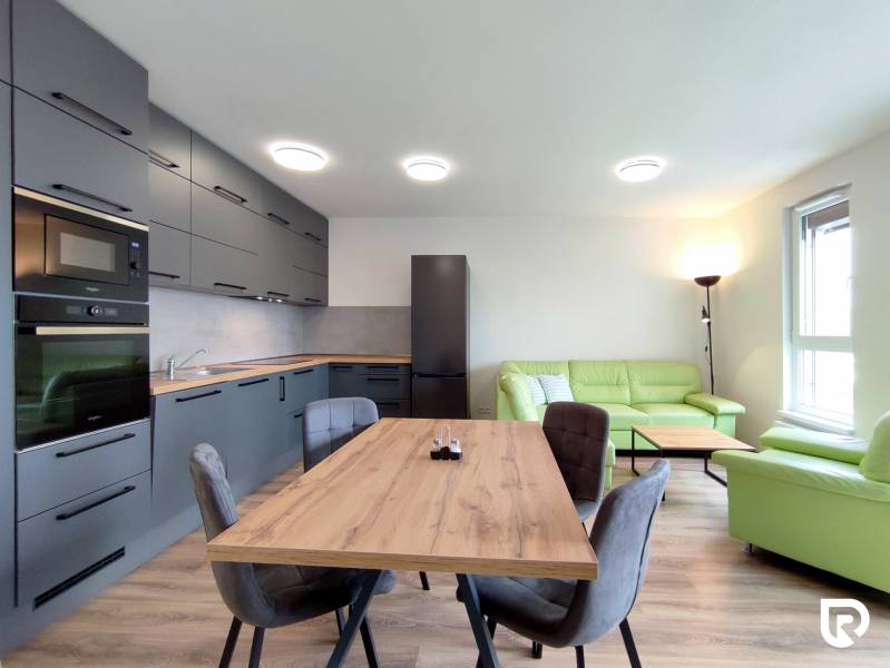 Helle Küche mit Esstisch und Sofa in einer 3-Zimmer-Wohnung mit Holzboden.