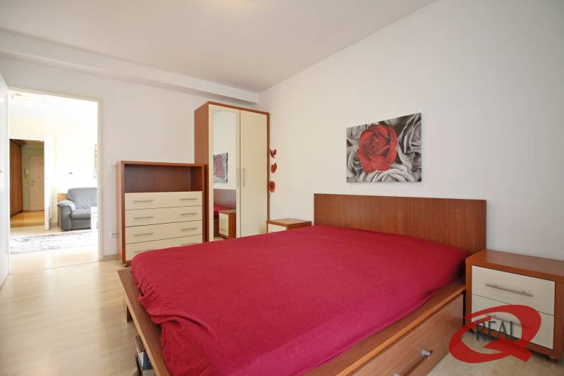 Schlafzimmer mit Holzboden, Bett, Schrank und Bild in einer 3-Zimmer-Wohnung.