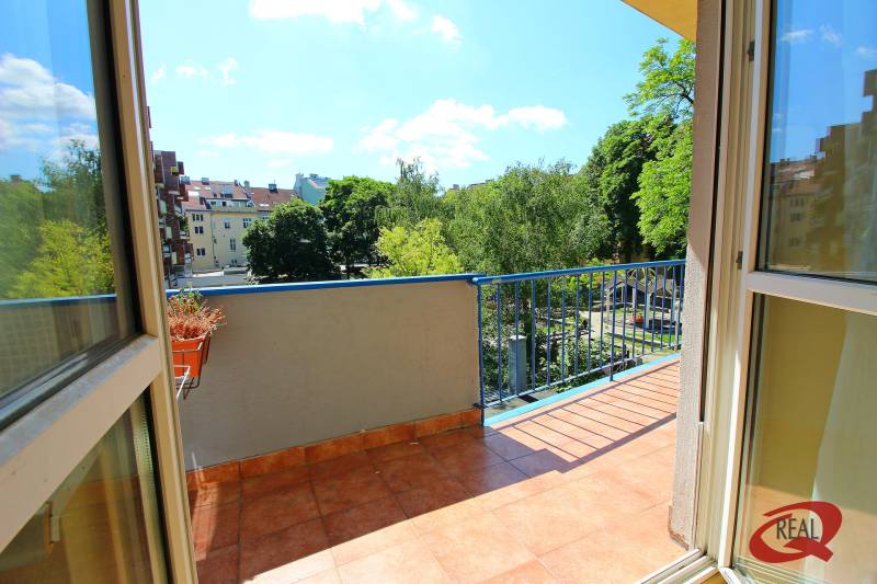 Balkon einer 3-Zimmer-Wohnung mit Blick auf Grünflächen und weitere Gebäude.