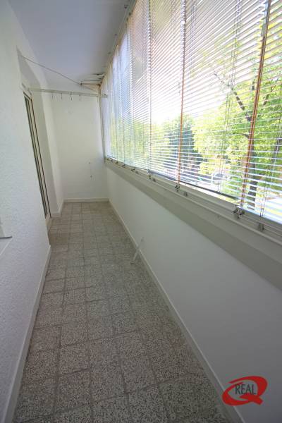 Veranda mit Glaswänden, Terrakottafliesen, Jalousien und Aussicht, geeignet für eine 3-Zimmer-Wohnung.