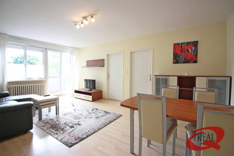 Wohnzimmer in einer 3-Zimmer-Wohnung mit Holzboden, Sofa und Esstisch.