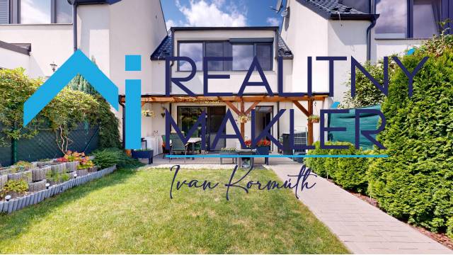 Garten und Terrasse bei einem Einfamilienhaus in Stupava mit gepflegtem Rasen und Blumenbeet.