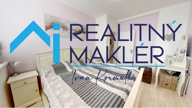 Schlafzimmer im Einfamilienhaus mit dekorativem Textil und Bodenbelag in Holzoptik.