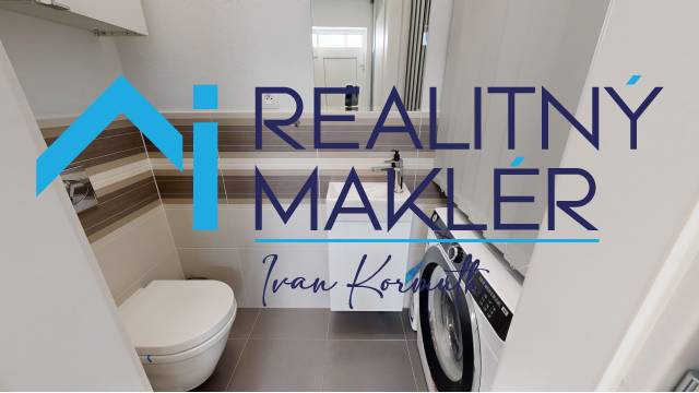 Badezimmer mit Toilette und Waschmaschine in einem Einfamilienhaus, helle Fliesen und Bodenbeläge.