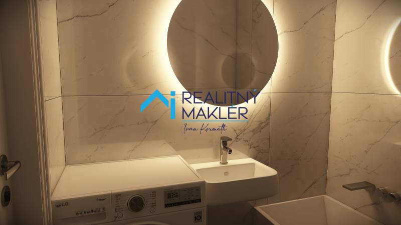 Badezimmer in einer 3-Zimmer-Wohnung mit hellen Fliesen und einer Waschmaschine.