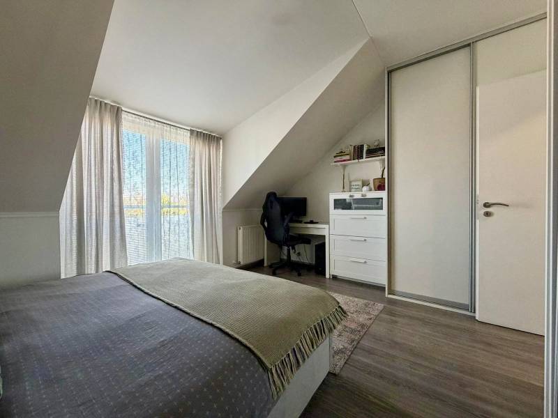 Schlafzimmer in einer 2-Zimmer-Wohnung mit Schreibtisch und Holzboden.