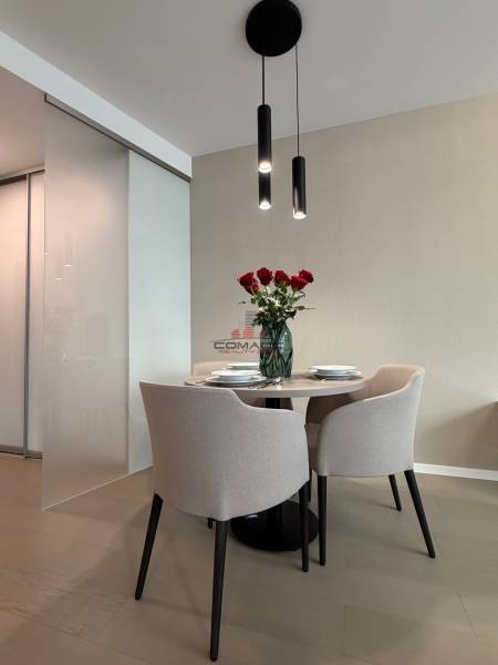 Essbereich mit Tisch und Stühlen, Boden mit Holzdekor in einer 2-Zimmer-Wohnung.