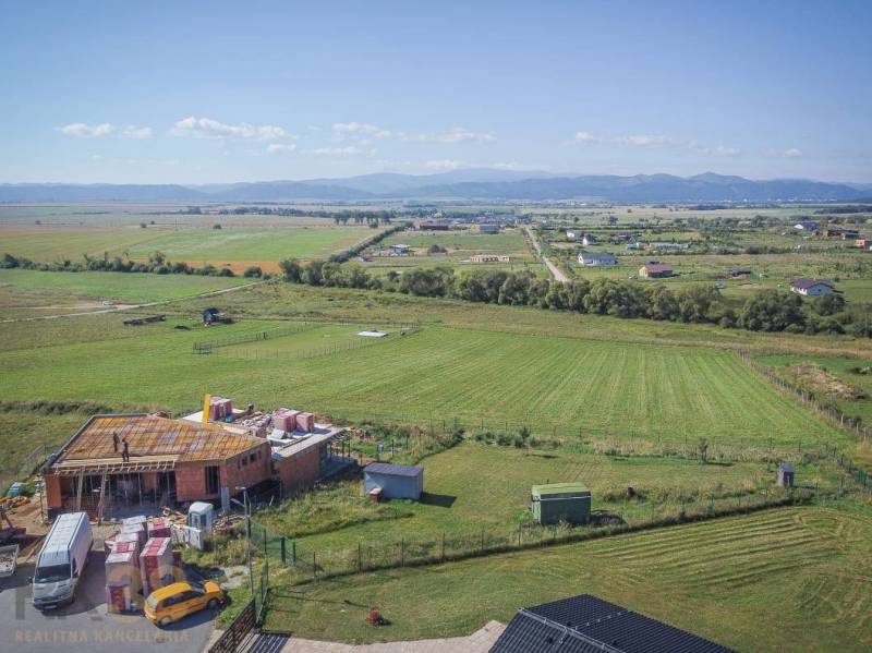Grundstücke - Wohnen in Mlynica mit Blick auf ein im Bau befindliches Gebäude und Naturszenerie.