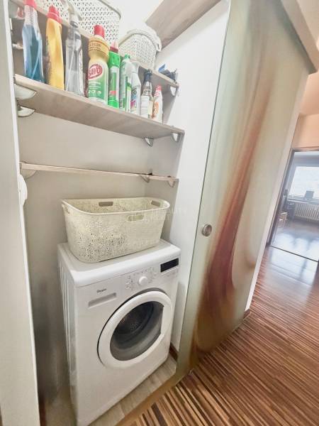 Waschmaschine und Reinigungsmittel in einer 4-Zimmer-Wohnung mit Holzboden.