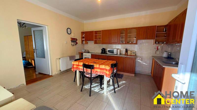 Eine Küche in einem Einfamilienhaus mit Holzdekor und einem orangefarbenen Tischtuch auf dem Tisch.