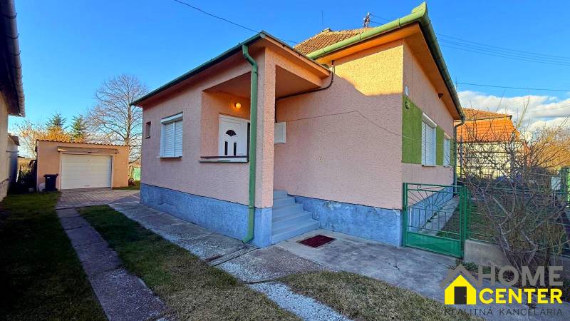 Ein Einfamilienhaus in der Stadt Iža mit Garage und gepflegtem Hof, ideal für eine Familie.