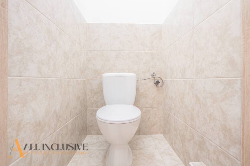 Eine Toilette mit hellen Fliesen in einem Gebäude.