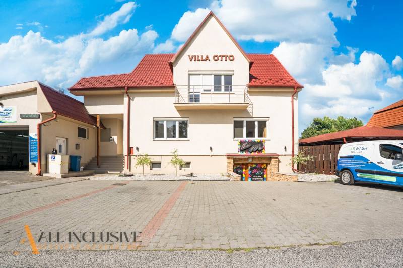 Ein Gebäude mit rotem Dach und reserviertem Parkplatz in Dunajská Streda.