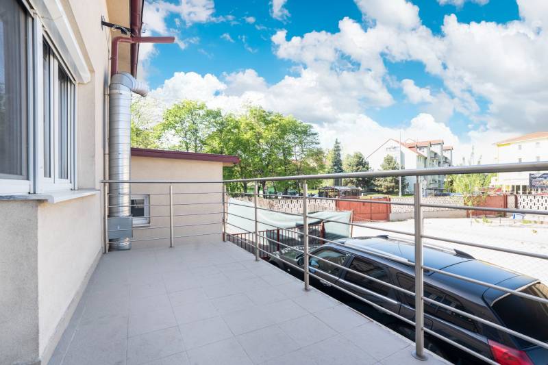 Ein Balkon in Dunajská Streda mit Blick auf die Umgebung von Gebäuden und einem Park.