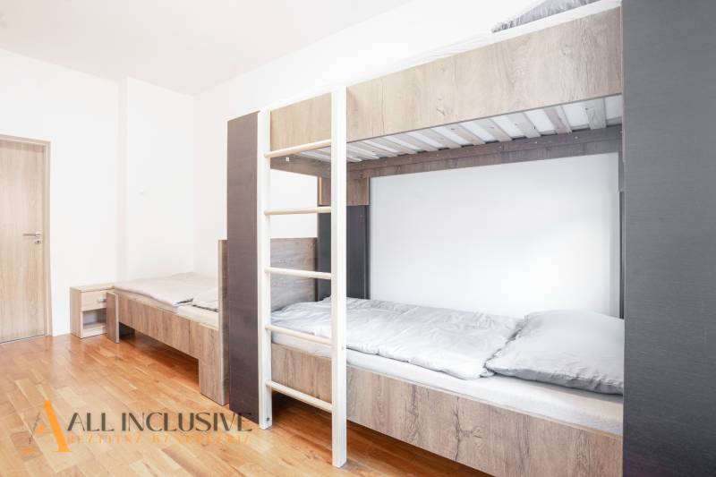 Innenraum mit Etagenbett und Holzboden in einem Gebäude.