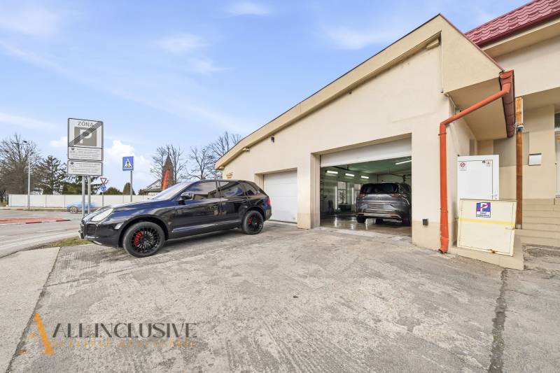 Ein Gebäude in Dunajská Streda mit Autos vor den Garagen und Verkehrsschildern.