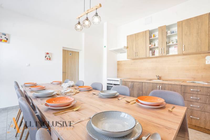 Eine Küche im Gebäude, Holzschränke, großer Tisch mit Holzboden-Dekor.