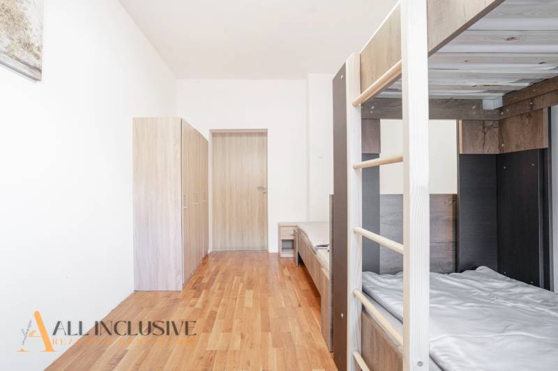 Ein Interieur mit einem Etagenbett, Schränken und einem Boden mit Holzdekor.