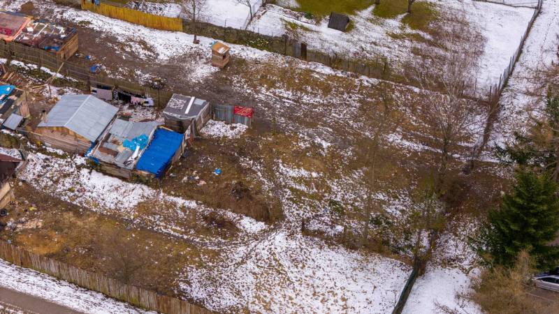 Gärten in Nálepkovo mit vereistem Schnee, älteren Unterständen und Zäunen im Winter.
