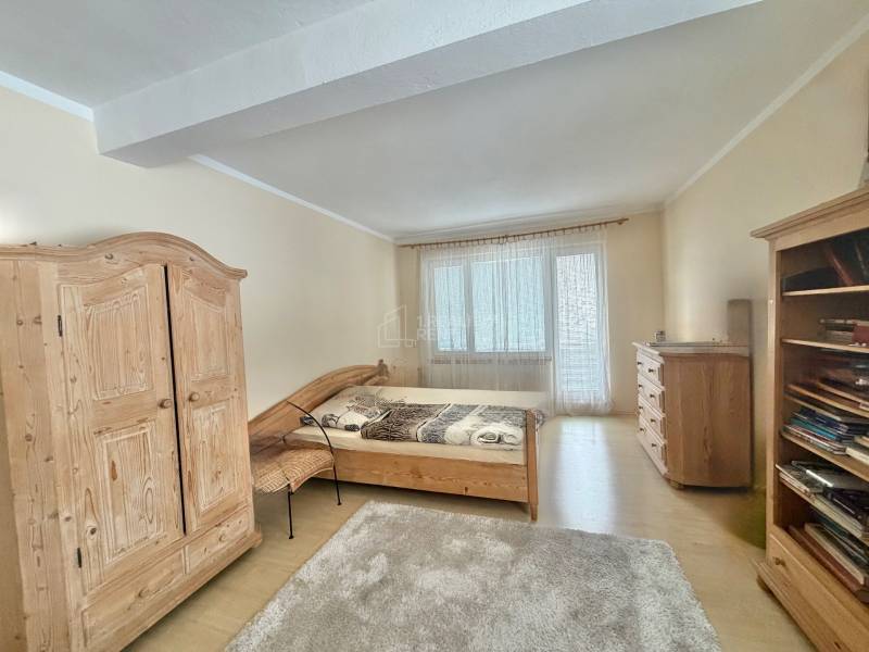 Schlafzimmer in einem Einfamilienhaus mit Holzmöbeln und einem Boden mit Holzdekor.