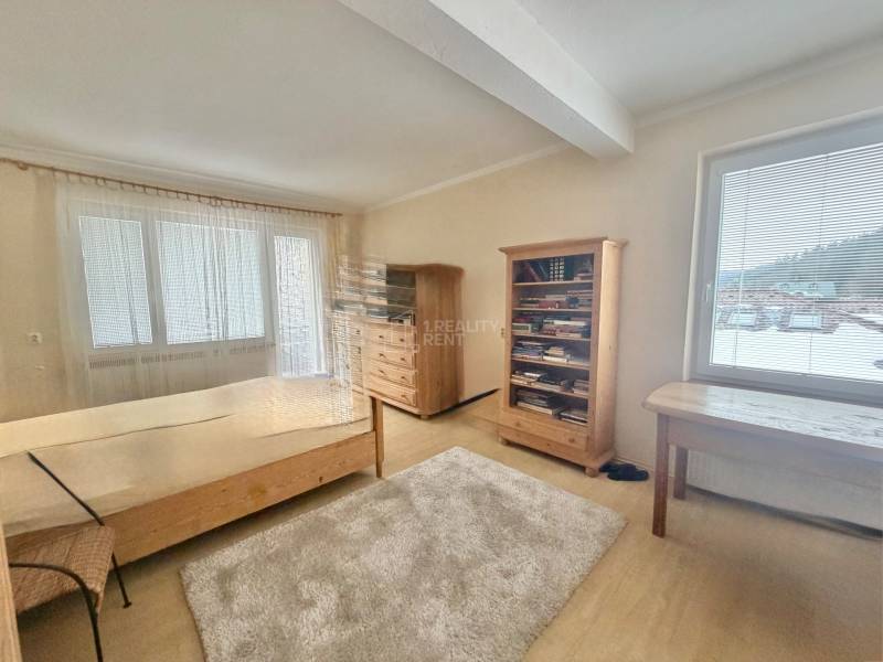 Zimmer mit Bett, Bücherregal und Tisch in einem Einfamilienhaus in der Straße Čadečka.