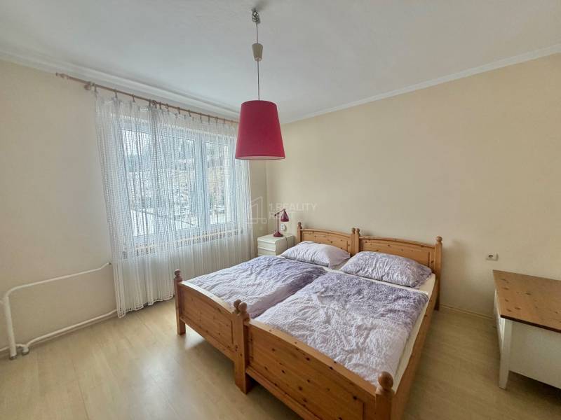 Schlafzimmer mit Doppelbett und Kronleuchter in einem Einfamilienhaus mit Holzboden.