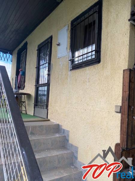 Eingangstreppen und Fenstergitter der Hütte in Vyšné Opátske, Košice, mit gelber Fassade.