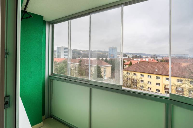 Ein verglaster Balkon mit Blick auf die Gebäude an der Straße SNP in Banská Bystrica.