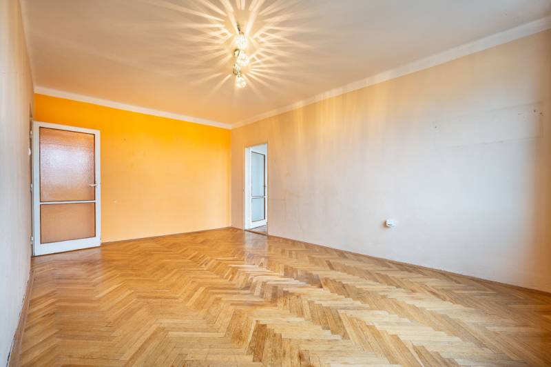 Helles Zimmer mit Holzdekorboden in einer 2-Zimmer-Wohnung mit bunten Wänden.