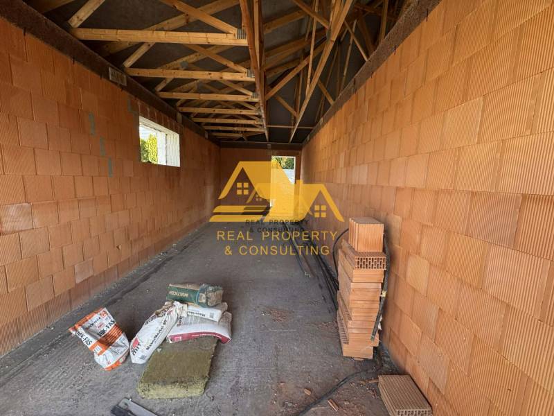 Bau eines Einfamilienhauses in der Straße in Nové Zámky mit Ziegelwänden und Balkendecke.