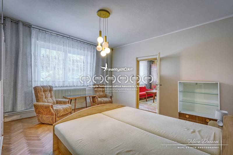 Ein Schlafzimmer in einem Einfamilienhaus mit hellen Holzmöbeln und bequemen Sesseln.