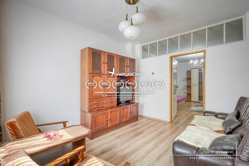 Wohnzimmer in einem Einfamilienhaus mit Holzmöbeln und bequemen Sitzgelegenheiten.