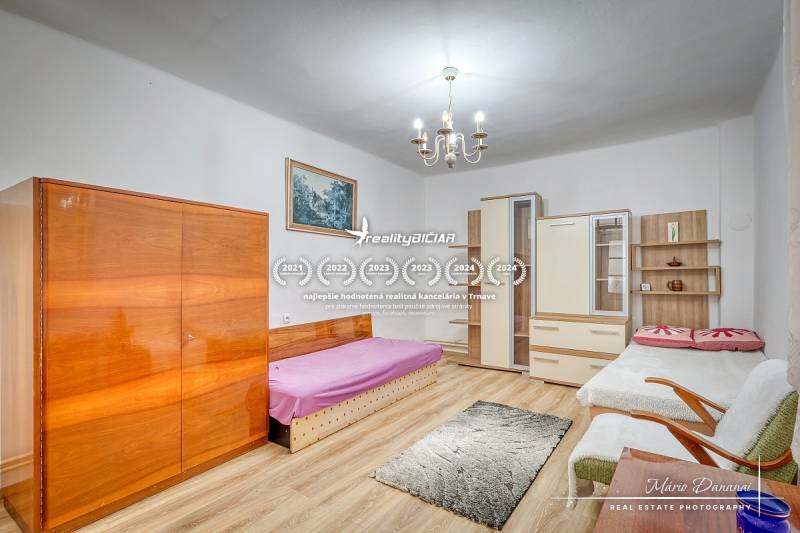 Izba s posteľou, skrinkami, gaučom a lustrom v rodinnom dome.

Zimmer mit Bett, Schränken, Sofa und Kronleuchter in einem Einfamilienhaus.