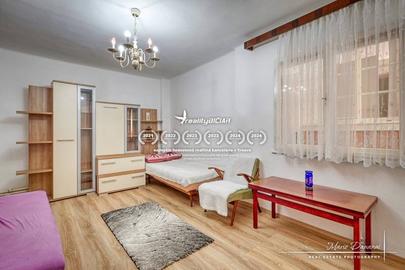 Ein Einfamilienhaus mit Holzboden, Kronleuchtern und Möbeln, ein Zimmer mit Tageslicht.