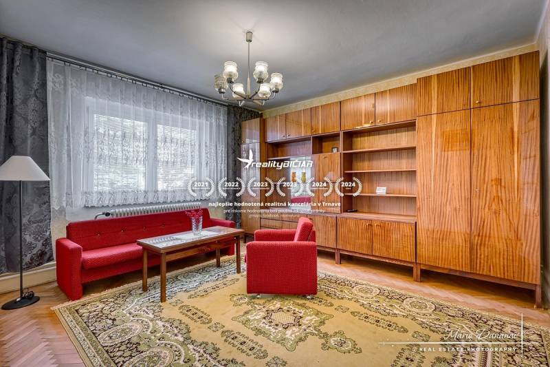 Wohnzimmer in einem Einfamilienhaus mit roten Sofas, Kronleuchter und Holzwand-Einheit.