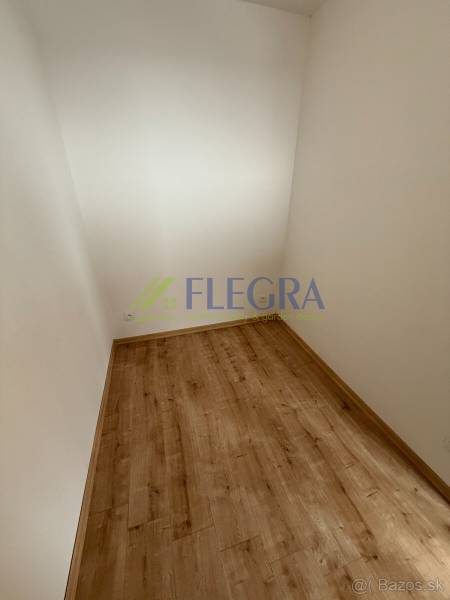 Ein kleiner Raum in einer Einzimmerwohnung mit einem Boden in Holzoptik.