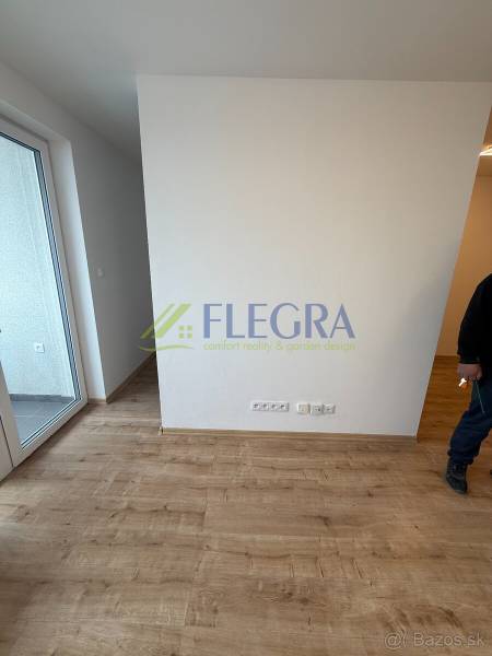 Innenraum in einer 1-Zimmer-Wohnung mit Holzboden und Balkon.