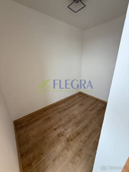 Ein leerer Raum in einer Einzimmerwohnung mit Holzboden und weißen Wänden.