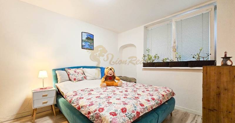 Ein Schlafzimmer in einem Einfamilienhaus mit einem Blumenmuster auf dem Bett und Dekorationen.