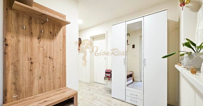 Eingangsbereich in einem Einfamilienhaus mit Schrank, Garderobe und Boden mit Holzdekor.