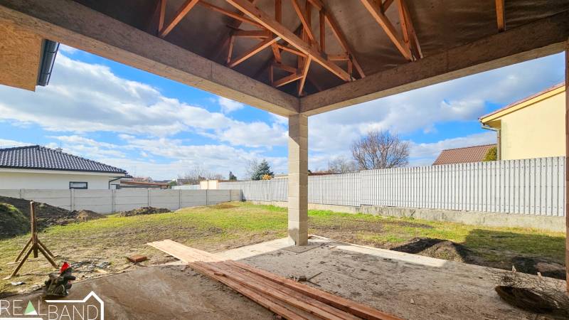 Bauablauf eines Einfamilienhauses in Pavlice mit Holzdachkonstruktion und gestaltetem Hof.