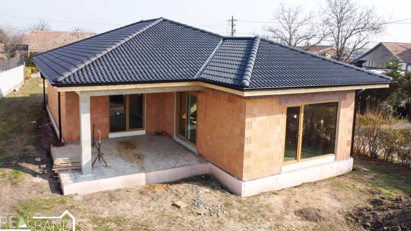Ein Einfamilienhaus in Pavlice mit schwarzem Dach und einer Terrasse im Garten.