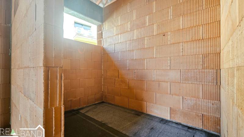 Leerer Raum in einem im Bau befindlichen Einfamilienhaus mit Ziegelwänden.