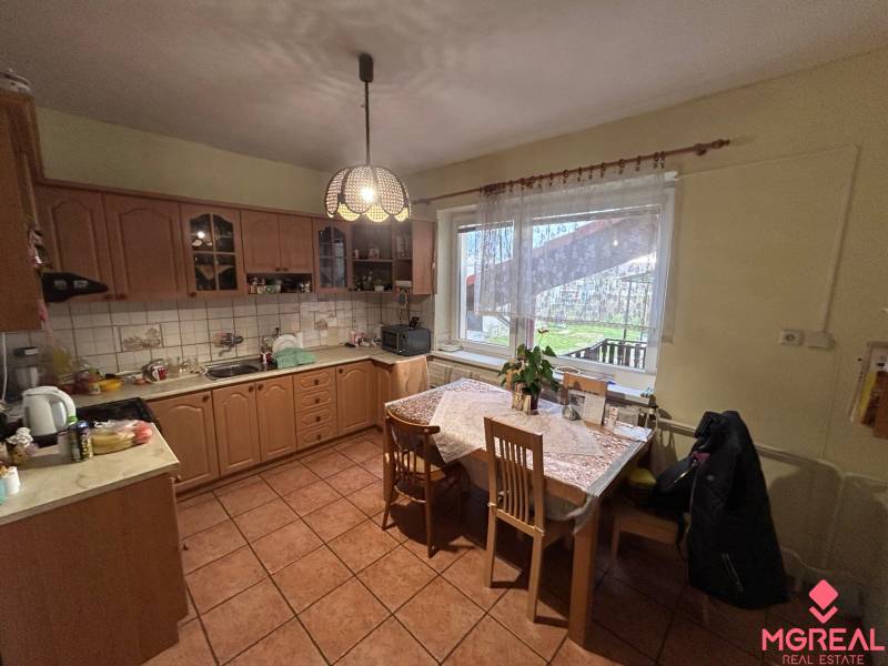 Küche in einem Einfamilienhaus mit Holzdekor und Esstisch.